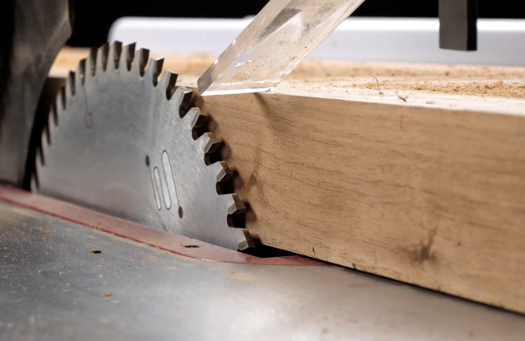 a grizzly extreme series blade mounted on a table saw that has just made a clean cut through a piece of hardwood
